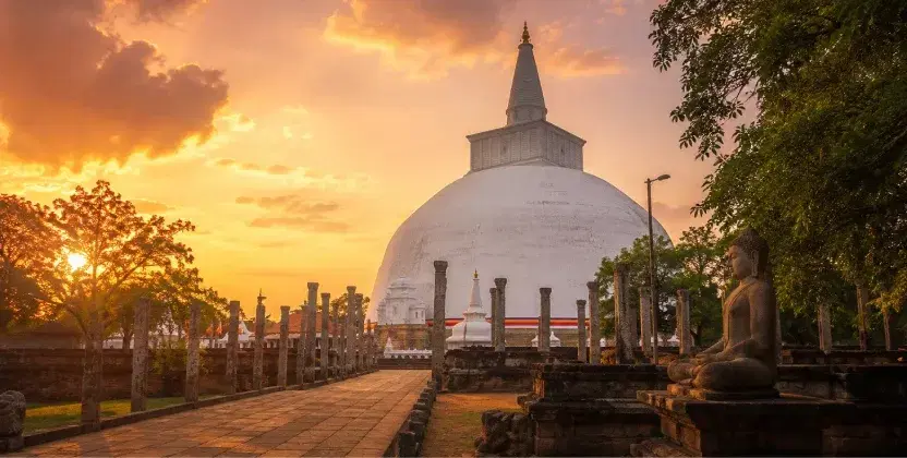 Anuradhapura stupa and ancient Buddhist ruins at sunset.