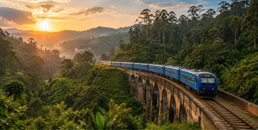 Ella train crossing a scenic stone viaduct surrounded by green mountains.
