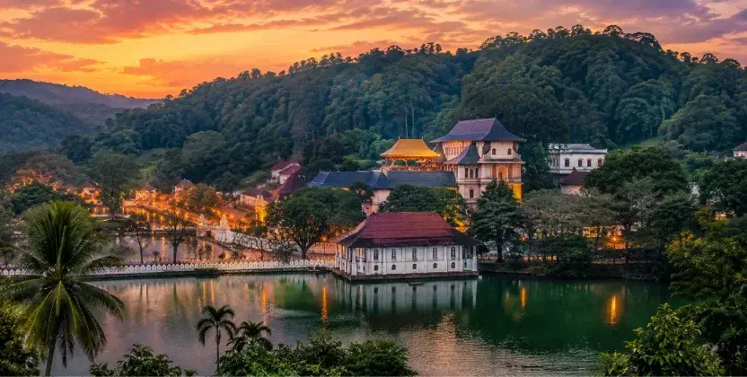 Kandy Temple of the Tooth beside the lake and forested hills. One of the best places to visit in Sri Lanka