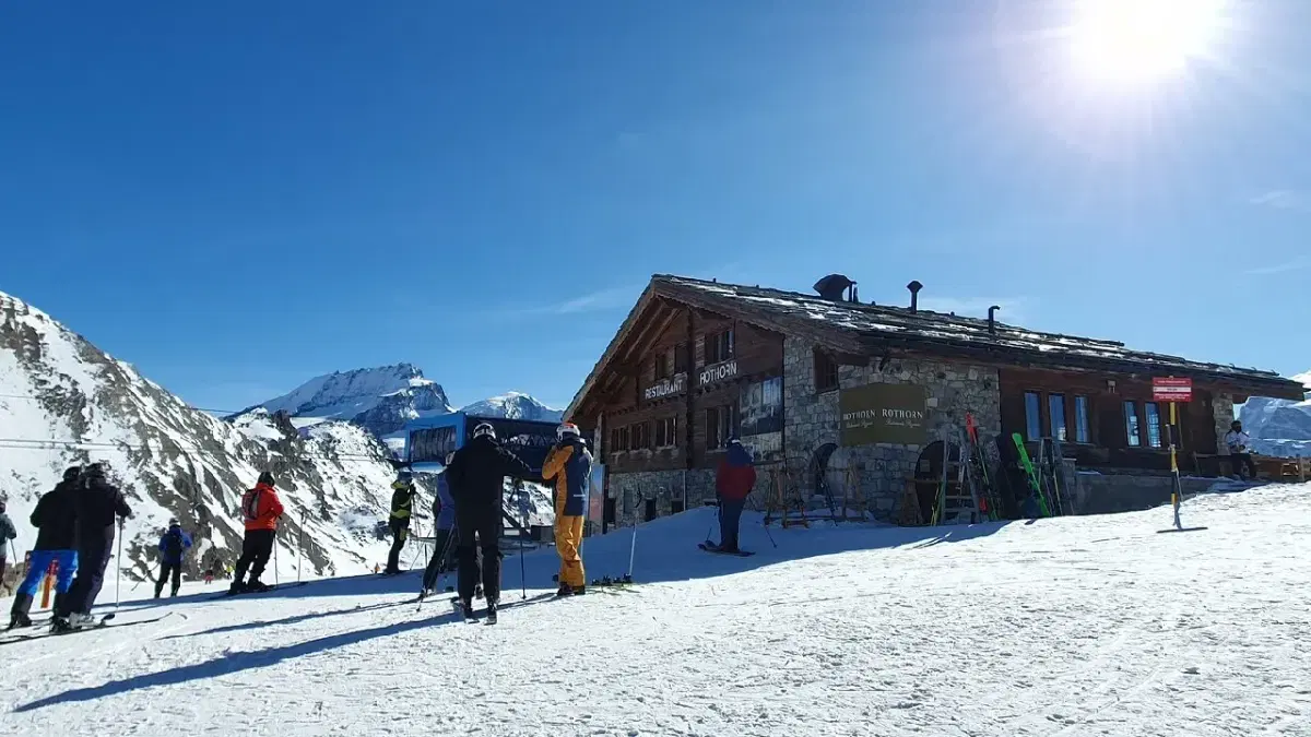 view of people skiing in front of a Hotel in Rothorn