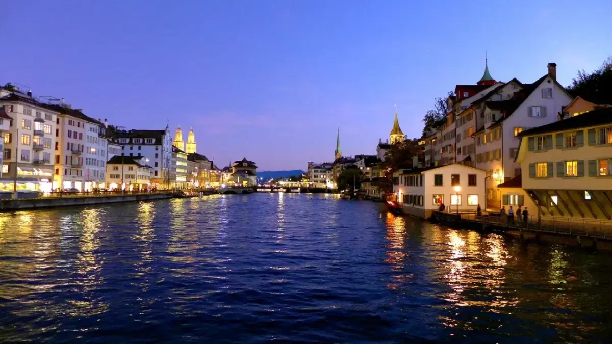 View of Zurich at night where the city lights reflect in the lake