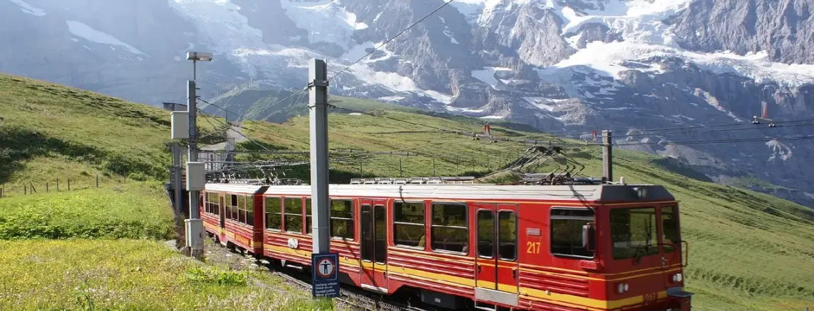 Jungfrau railway train to Junfraujoch running in front of the swiss alpine peaks
