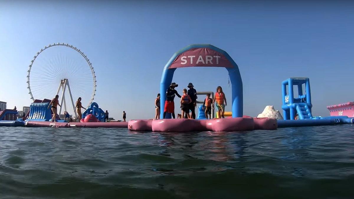 People playing on giant inflatable obstacle course at AquaFun, the world’s largest floating water park in Dubai.