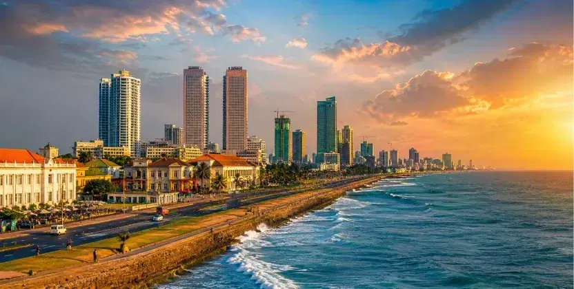 Places to visit in Sri Lanka: Colombo coastal skyline at sunset with the ocean and city buildings.