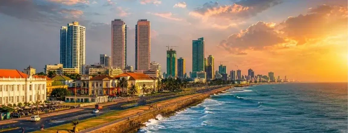 Places to visit in Sri Lanka: Colombo coastal skyline at sunset with the ocean and city buildings.