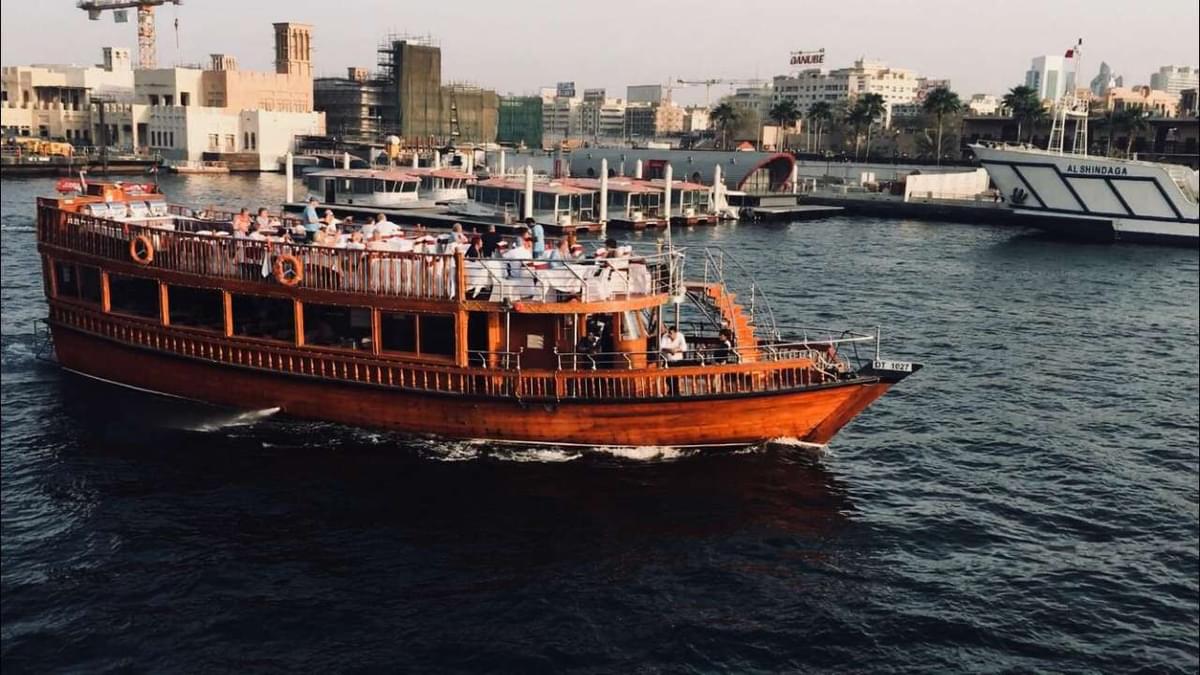 Classic wooden dhow cruise sailing in the waters of Dubai, offering traditional Arabian experiences for tourists.